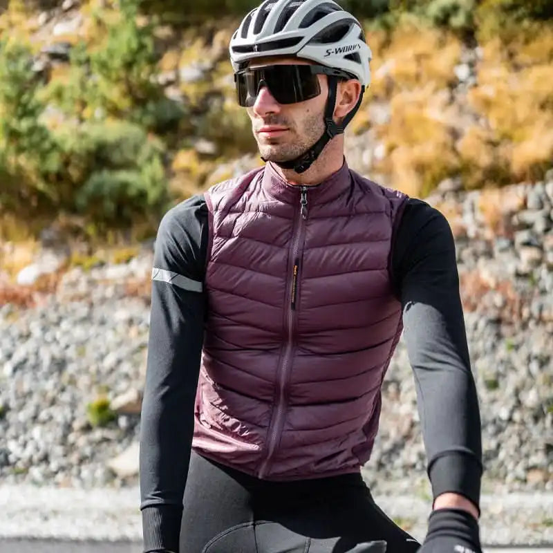 Mann i burgunder vattert sykkelvest, hvit S-Works hjelm og store solbriller på sykkeltur utendørs.