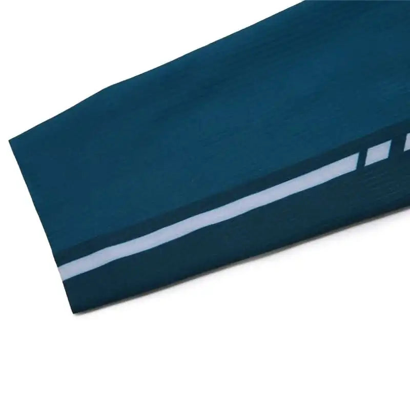 Nærbilde av ermet på en mørkeblå sportstrøye med hvit refleksstripe i et teknisk materiale.
