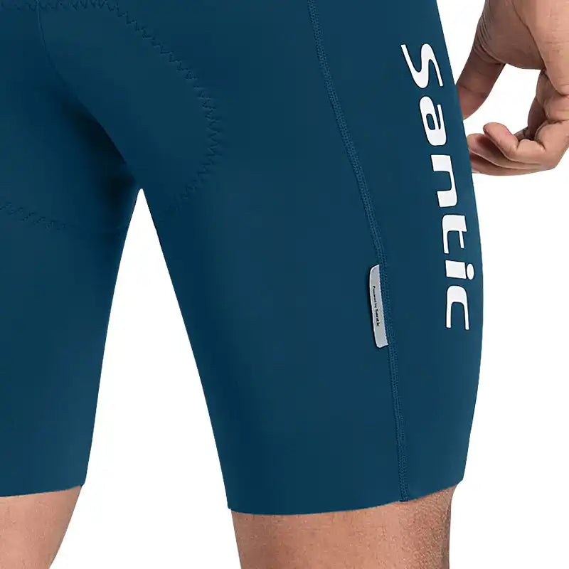 Mørkeblå sykkelshorts fra Santic med hvit logo på siden og synlig polstring bak.