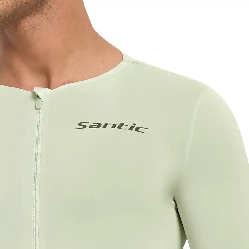 Nærbilde av en lys grønn Santic sykkeltrøye med logo på brystet.