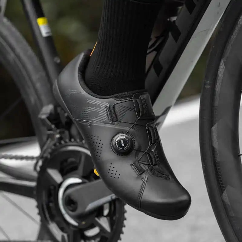 Svart landeveissko med Atop-strammehjul montert på en pedal på en landeveissykkel.